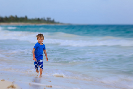 小男孩在热带沙滩上运行