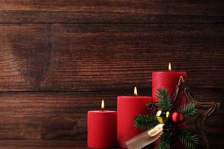 木制桌上的圣诞树树枝和小的圣诞蜡烛