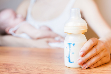 妈妈抱着奶瓶用母乳与规模照片