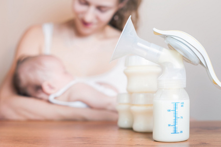 手动吸奶器和喂养刚出生的婴儿的母亲
