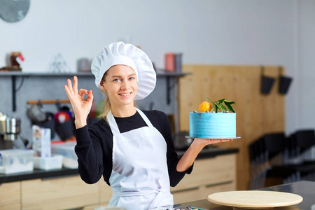 一个糖果的女人在厨房里手里拿着蛋糕