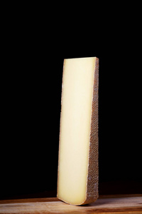 在黑色背景上的一大块瑞士奶酪。侧面视图。牛奶产品从牛奶