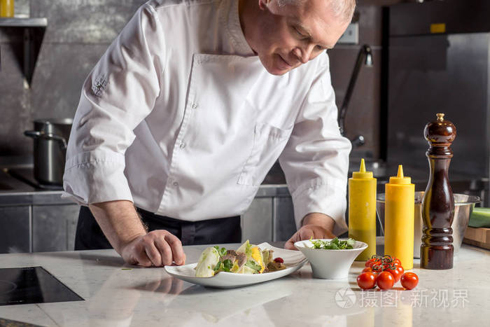 男性在餐厅厨房做饭的厨师