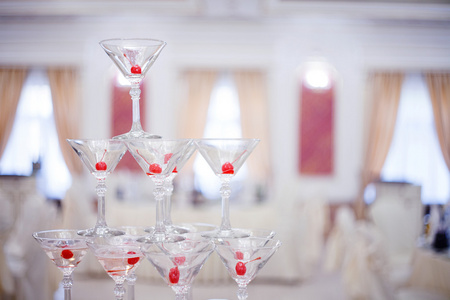 玻璃酒杯。金字塔的香槟。小山杯葡萄酒和樱桃。为酒精。节日的饮料。调酒师表演。装饰品的宴会。小深度字段