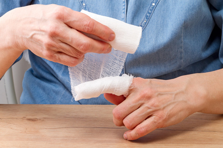 女人用绷带包扎她的手指照片