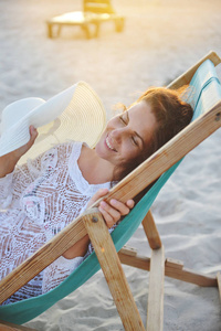 夏天, 一个年轻的女人坐在沙滩上的椅子上