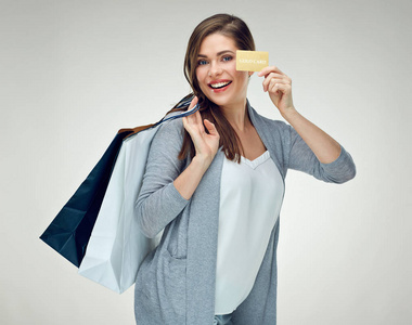 休闲着装快乐的女人拿着购物袋和信用卡成功购物
