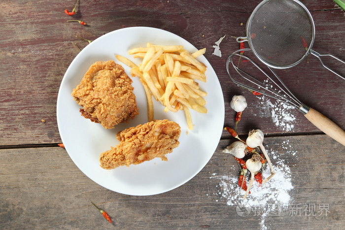 炸的鸡翅配薯条在木桌上从查看