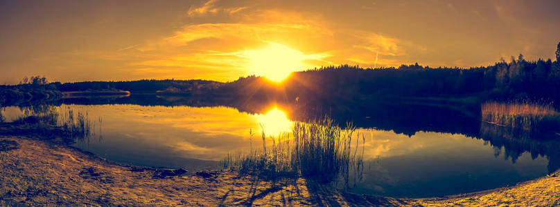 夏天风景与日落在湖。美丽的橙色日落或日出在森林和和平的水反射太阳光, 温暖的风景在自然