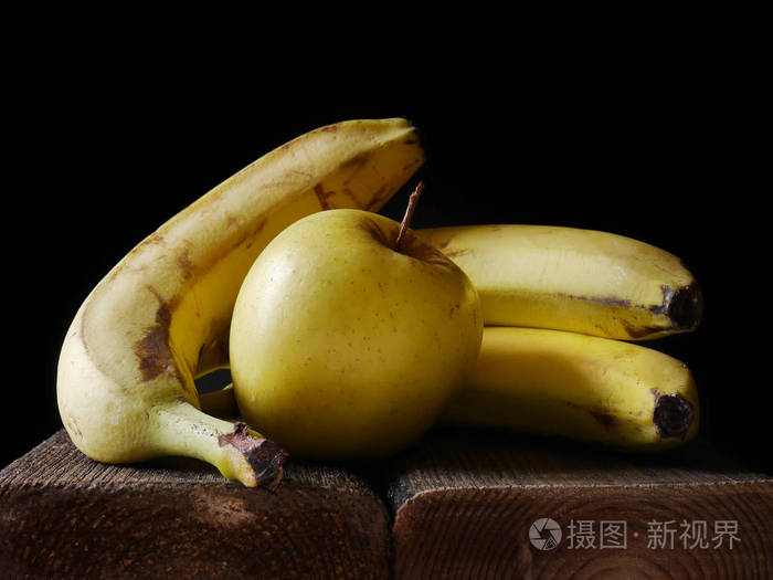 香蕉和苹果的静物成分在黑暗的背景