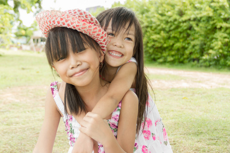 小的亚洲女孩与她的妹妹公园里玩