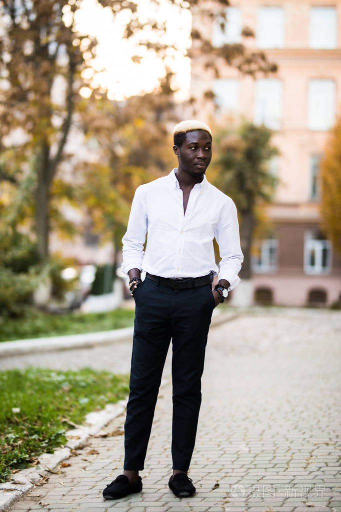 一个英俊的男人在秋街行走的全身画像