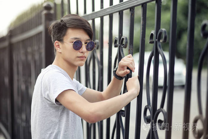 亚洲青年男子戴墨镜户外