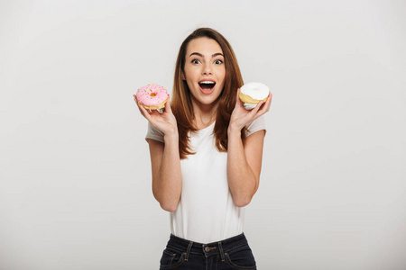一个快乐的年轻女人拿着甜甜圈的肖像
