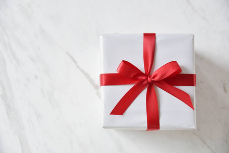 带红色丝带的白色礼品盒顶部视图照片