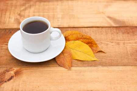 一杯咖啡在木桌上落叶