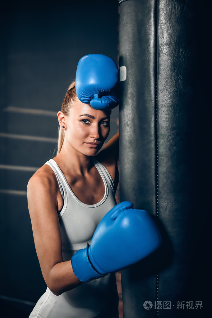美丽的金发女子拳击手附近的出气筒