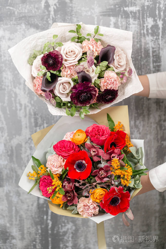 两个美丽的豪华花束在女性手中的混合花卉.花店花匠的工作
