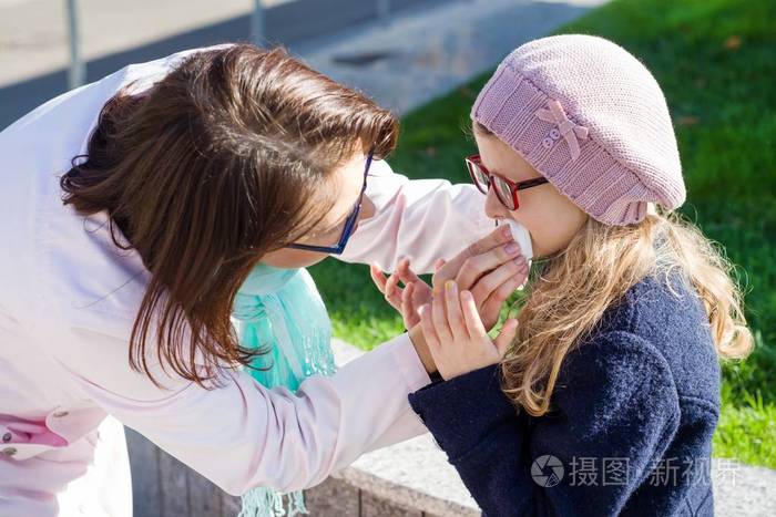 母亲用纸巾擦女儿的嘴