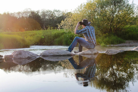 年轻的牛仔钦佩 riv 上春天的傍晚的夕阳