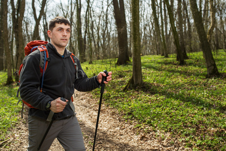 男性的徒步旅行者寻找到的一侧走在森林