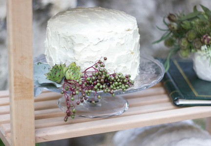 用绿色植物装饰的白色婚礼蛋糕