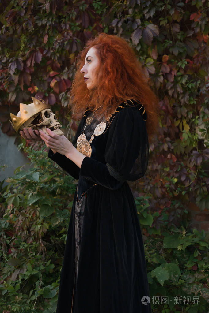 一只手拿着剑的中世纪女王和骷髅