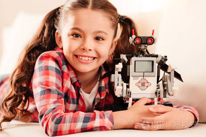 拥抱她新的机器人玩具的喜气洋洋的小女孩