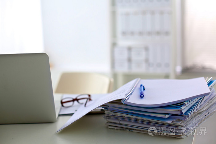 一叠文件在计算机桌上