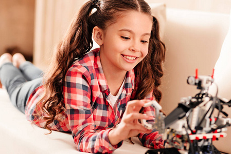 快乐的年轻女士在休闲玩机器人机器照片