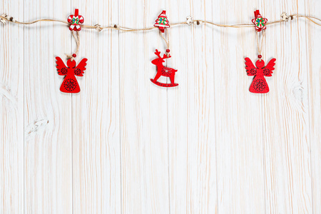 圣诞木红色玩具的形状, 鹿和天使的绳子在白色的木制背景。美丽喜庆贺卡与自由空间