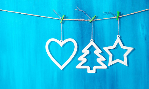 蓝色背景上悬挂在绳子上的老式圣诞装饰品