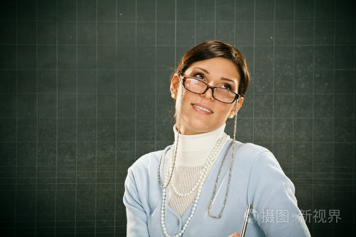 年轻漂亮的微笑老师戴着眼镜,blackbouard照片-正版商用图片0ekbx1-摄