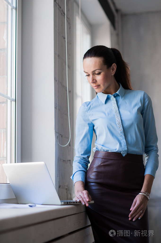 年轻成功幸福微笑业务的女人在笔记本电脑上