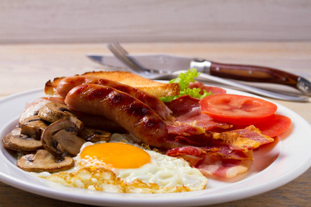 传统英语或爱尔兰早餐 香肠培根鸡蛋蘑菇西红柿和土司。营养丰富的晨餐。水平