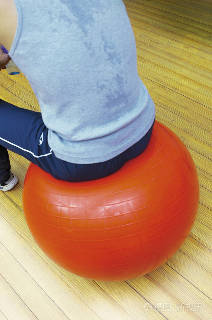 在健身球上休息的年轻男性运动员的裁剪镜头