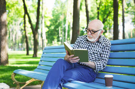 老人在户外休闲阅读图片