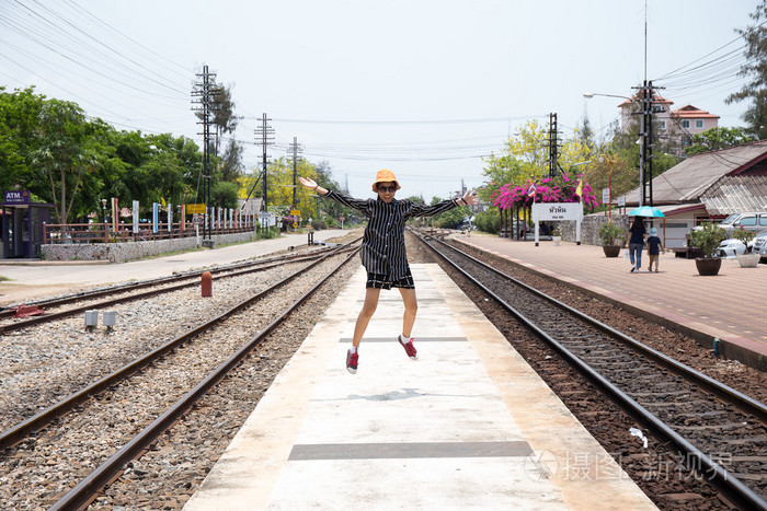 亚洲年轻漂亮的女孩在铁路上行走