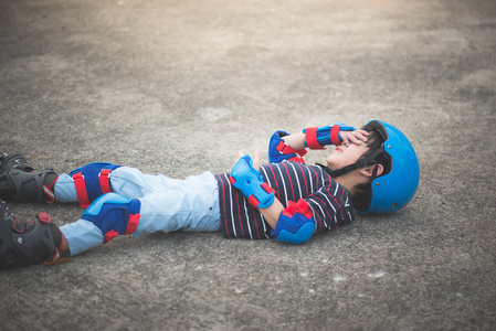 的男人落绊倒摔倒了亚洲儿童跌倒, 而旱冰在公园里黄色三角形的标志