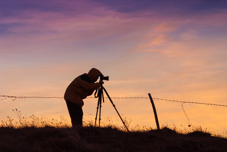 摄影师用相机拍照的剪影照片