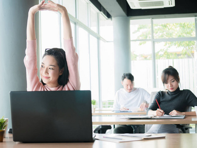 商业女性放松 满意的业务女人双臂在空中坐在椅子上，放松在办公室