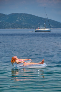 年轻女子在海中的充气床垫