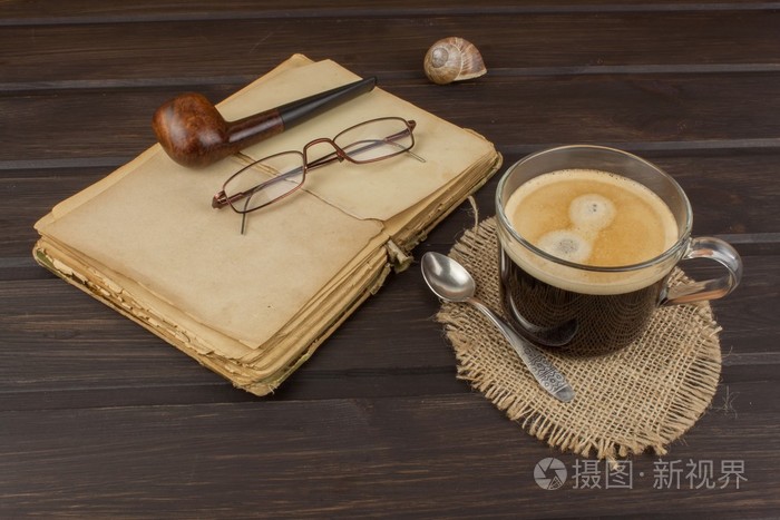 老书眼镜和杯咖啡黑木制的桌子上阅读经典老书和咖啡有一本书和一杯好