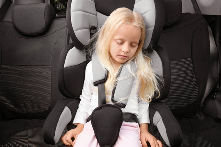 金发女孩睡在儿童安全座椅图片