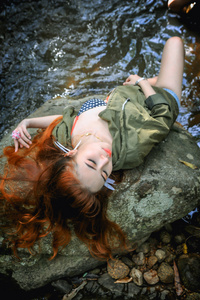 亚洲年轻漂亮的女孩躺在岩石上