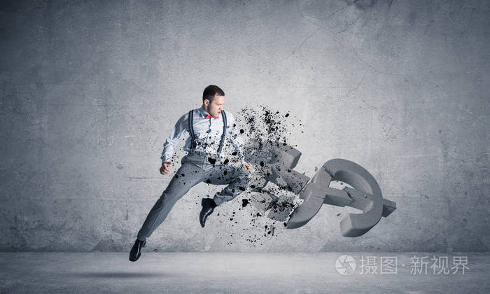 年轻的愤怒的商人跳跃和粉碎与踢石美元符号在空混凝