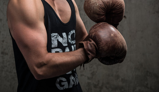 强硬的白种人男性,戴着老式拳击手套,准备打拳照片