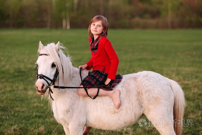 小女孩赤脚坐在一匹白马