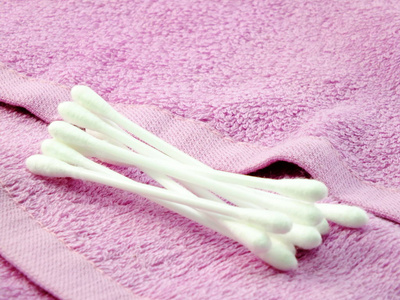 粉红色毛巾上的塑料棉芽组