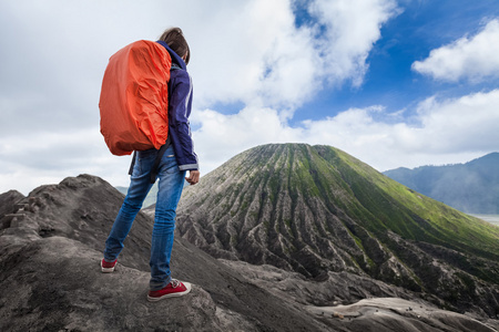 站在火山口边缘的背包客图片